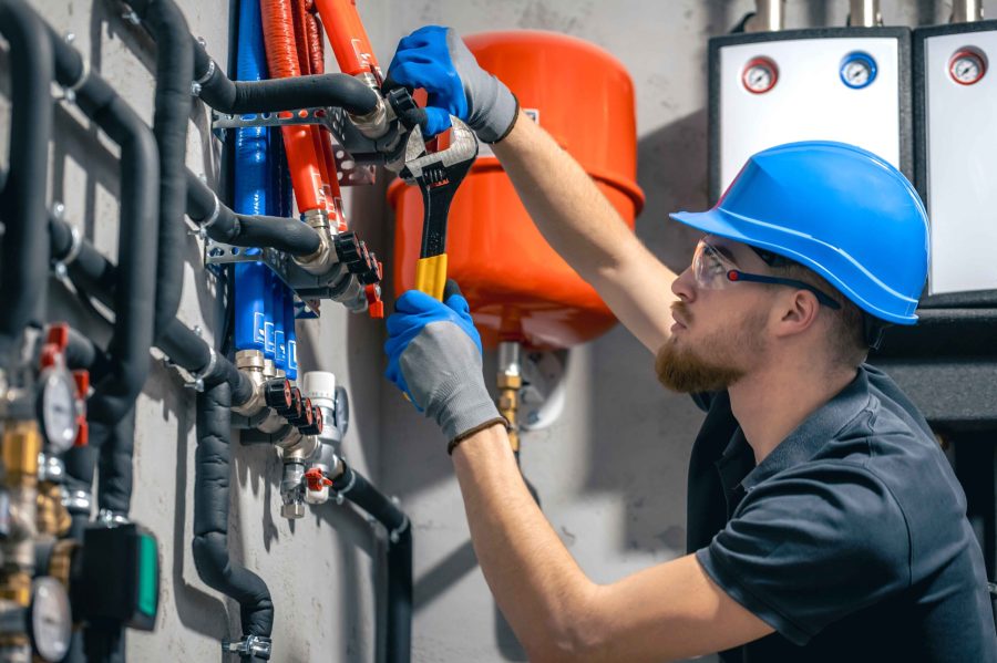 man-installs-heating-system-house-checks-pipes-with-wrench (1) man-installs-heating-system-house-checks-pipes-with-wrench (1)