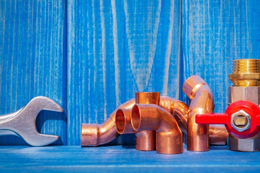 spare-parts-with-copper-plastic-accessories-plumbing-repair-blue-vintage-wooden-boards_192985-1557